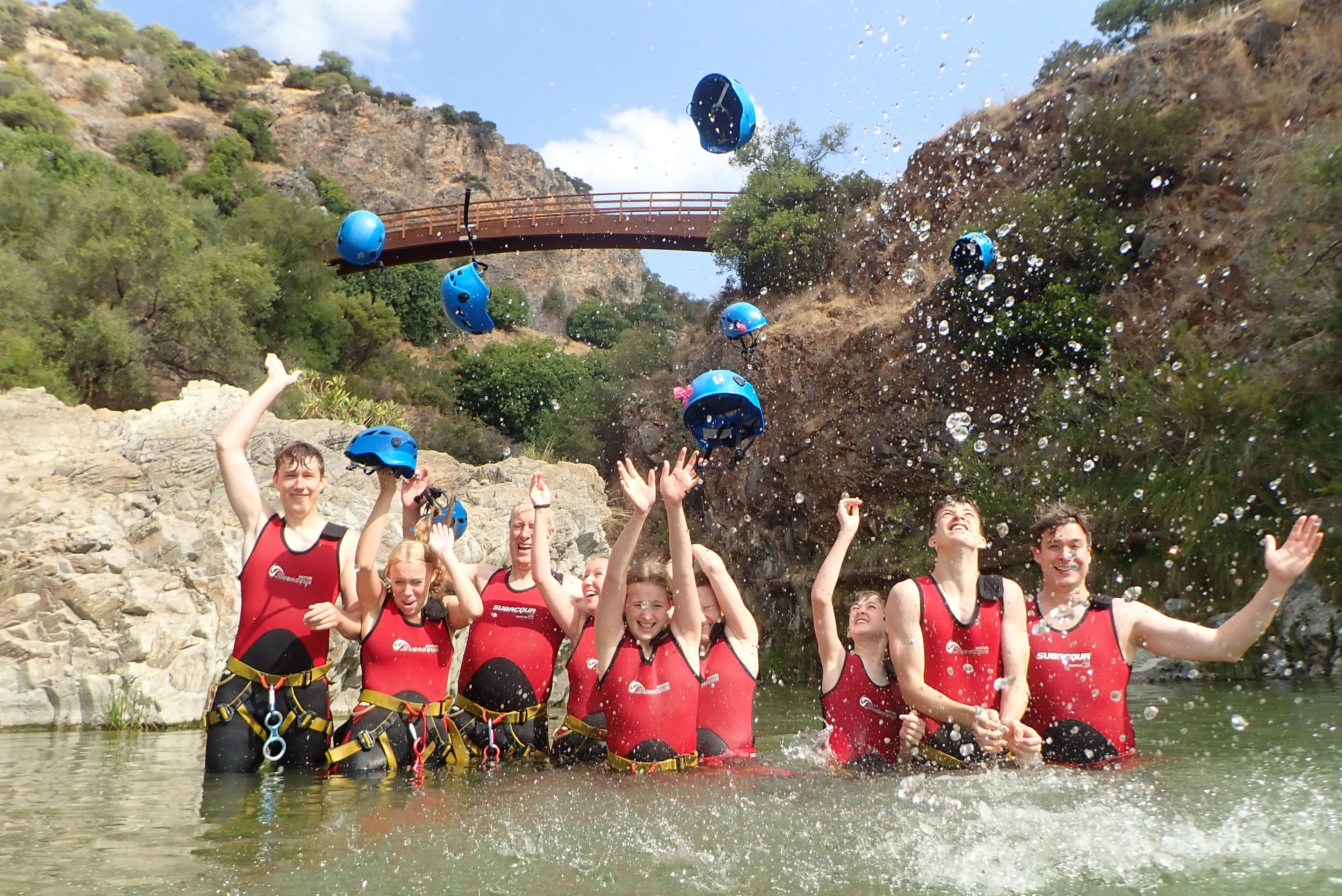 Group celebrating the end of a Guadalmina canyoning adventure by the river bridge