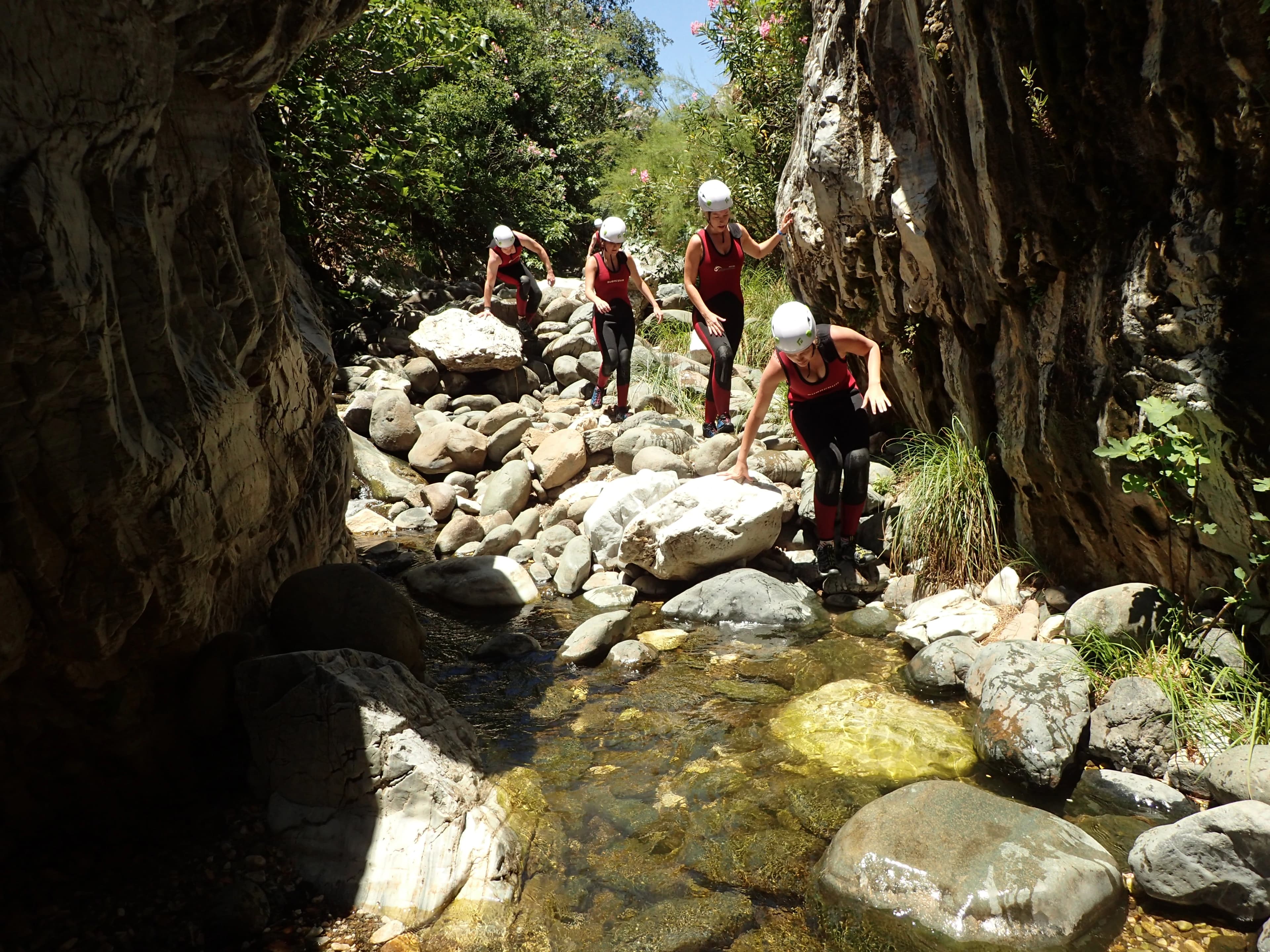 Group scrambling over boulders through the Guadalmina canyon near Benahavís